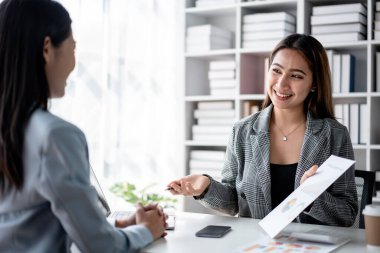 İş arkadaşlığı konsepti, iş arkadaşı yeni bir başlangıç stratejisi hakkında fikir alışverişinde ve tartışmasında işbirliği yaparken, finans evraklarını bir arada tutuyor ve ofiste buluşuyorlar..
