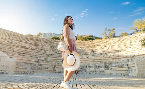 Antalya, Türkiye 'de Antalya' da Antiphellos amfitiyatrosunun genç yetişkin kadın turistle geniş açılı günbatımı fotoğrafı