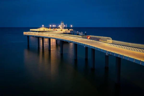 The new modern pier in Koserow, Usedom, northern Germany, opened in 2021, lit during the blue hour after sunset