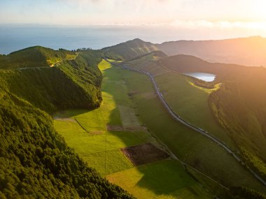 Portekiz, Azores Adaları 'ndaki Sao Miguel adasının hava manzarası. Kraterleri, tarlaları, çayırları ve ormanları olan tipik bir manzara. Arka planda Atlantik Okyanusu.