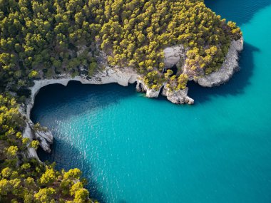 Gargano yarımadasının kıyı bölgesinin havadan görünen mağaraları ve uçurumları. Turkuaz Adriyatik Denizi üzerinde güzel beyaz kayalar.
