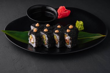 Sushi rolls with tuna and caviar on black plate