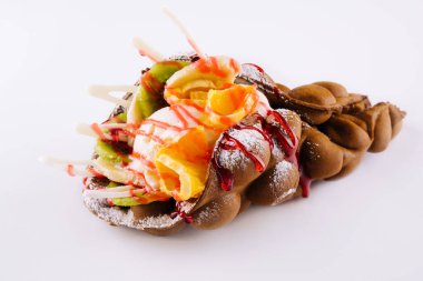 Egg waffle with ice cream and fruits with syrup