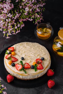 cheesecake with poppy seeds decorated with fresh strawberries