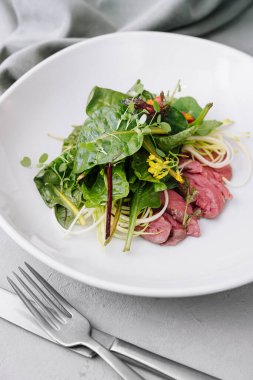 warm meat salad on white plate