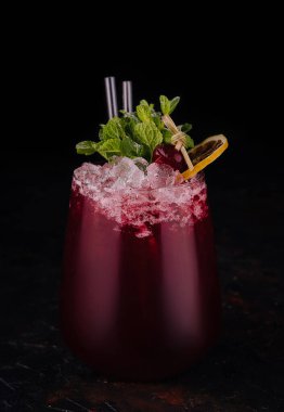 glass of red soft drink on black background
