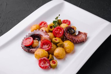 Fresh octopus salad with potatoes and olives on plate
