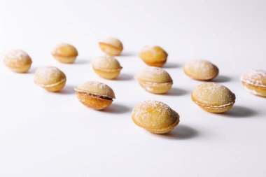 Walnut shaped cookies with cream on white