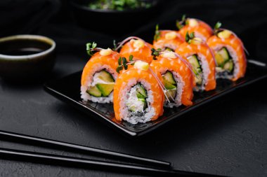 Siyah tabakta avokadosu olan Philadelphia Sushi.