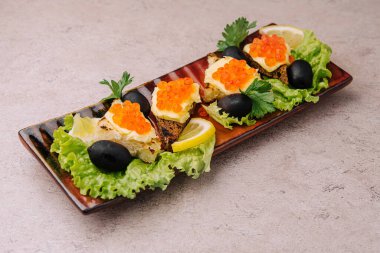 Bruschetta with red caviar on a plate