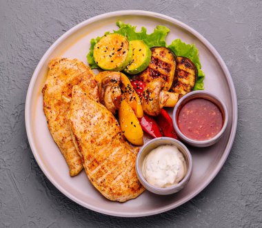 grilled chicken breast with vegetables and sauces