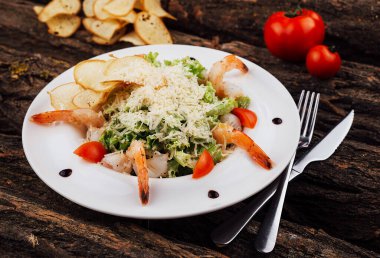 Caesar salad shrimps on white plate