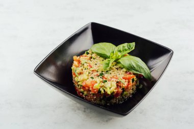 couscous tartare with vegetables in black plate