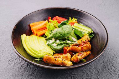 Grilled chicken breast salad with avocado and cucumbers, peppers and carrots