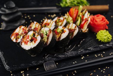 Vegetarian maki sushi rolls on black plate