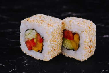 vegan sushi rolls with sesame seeds, peppers and cucumbers
