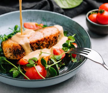 Grilled salmon with vegetables and sour cream sauce