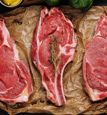 Tahta bir tahtanın üzerinde üç çiğ biftek.