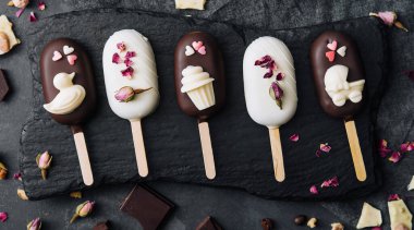 Top view of decorated cake pops ice creams on black background