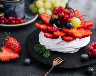 Taze böğürtlenlerle süslenmiş mini pavlova kremalı pasta.