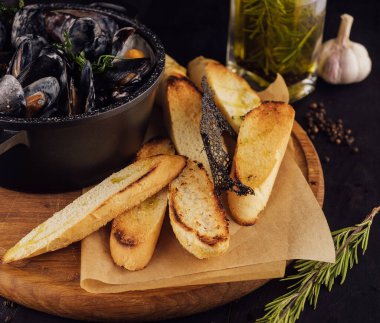 Traditional barbecue italian blue mussel in wine sauce with baguette bread