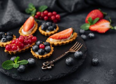 Siyah tahtada meyveli ve kremalı mascaropne soslu lezzetli tartlar