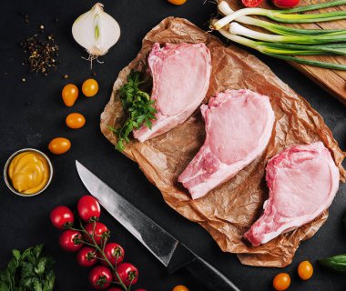 Pişirme kağıdında bir sürü çiğ biftek var.