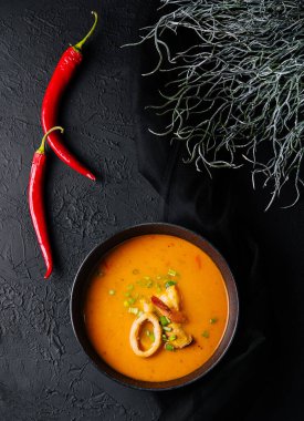 Tom yer elması çorbası, yukarıdan, siyah taşın üzerinde.