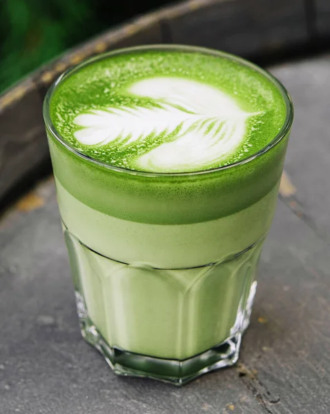 stock image Matcha latte green milk foam cup on wood barrel