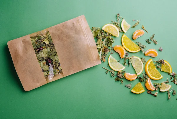 Blatttee Verschüttet Aus Einem Päckchen Mit Orangen Und Mandarinenscheiben — Stockfoto