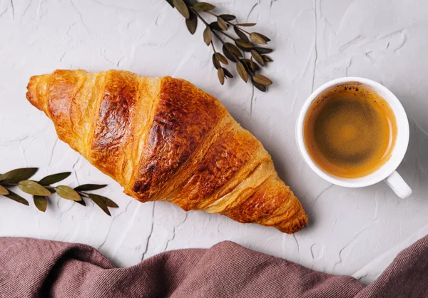 stock image Sweet croissant with a cup of coffee and a linen towel