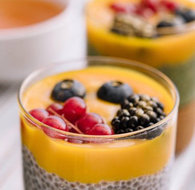 Mango soslu ve taze meyveli sağlıklı vegan chia pudingi.