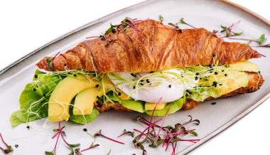 Croissant benedict salmon with poched egg, served with fresh salad