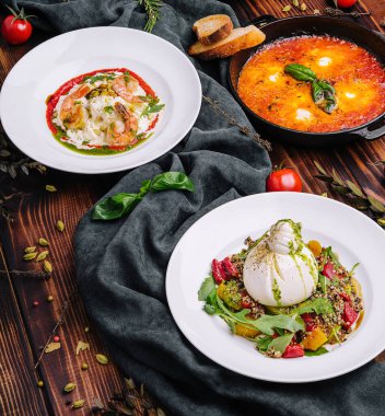 Büyük ahşap bir masada farklı İtalyan yemekleri.