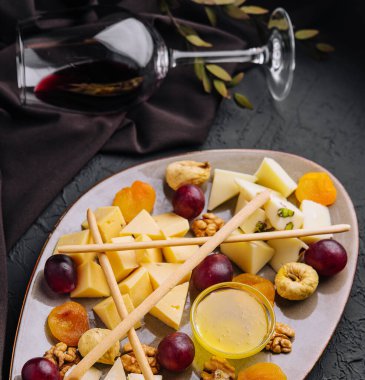 Cheese platter with organic cheeses, fruits, nuts and wine