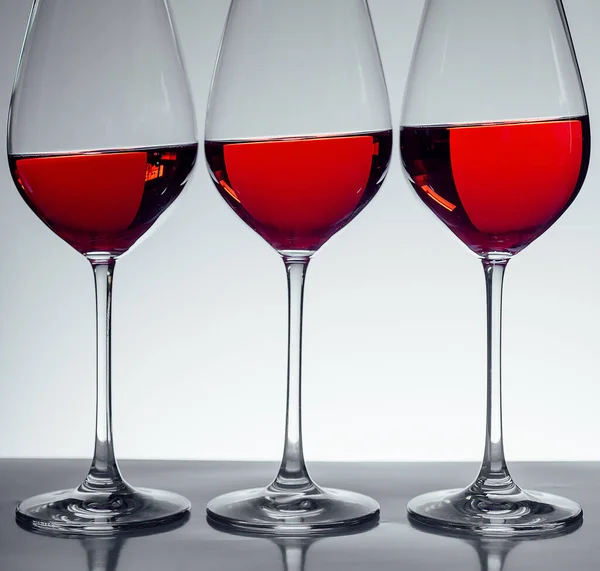 Serangkaian Tiga Gelas Anggur Dengan Latar Belakang Abu Abu — Stok Foto