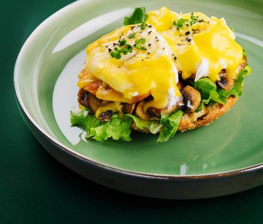 Yeşil tabakta Benedict yumurtası.