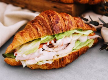 Jambonlu, domatesli ve marullu kruvasan sandviç.