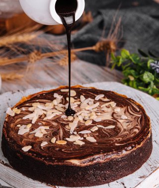 Cocoa brownies pouring with melted dark chocolate