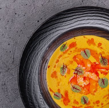 Tom yum çorbasını siyah tabağa koy.