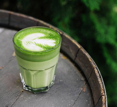 Kibrit latte yeşil süt bardağı ahşap fıçıda.