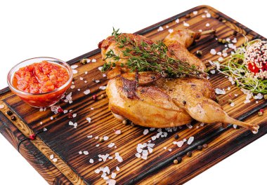 Roasted partridge with sauce tomato on wood board