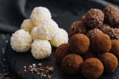 Taş tahtada üç çeşit çikolata topu var.