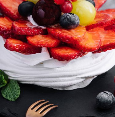 Taze böğürtlenlerle süslenmiş mini pavlova kremalı pasta.