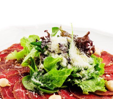 Beyaz tabakta parmesan peynirli dana carpaccio