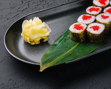 Siyah tabakta kırmızı havyarlı Maki Suşi.