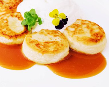 Ekşi kremalı krep ve beyaz tabakta reçel