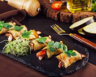 Kara tahtada biberle doldurulmuş patlıcan ruloları.