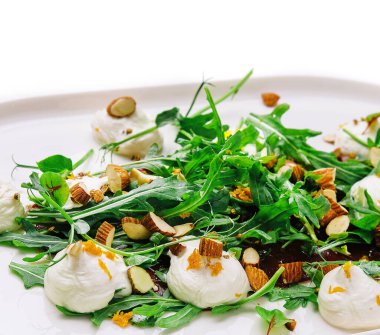 Çiğ badem dilimleri ve burrata peynirli Arugula salatası.