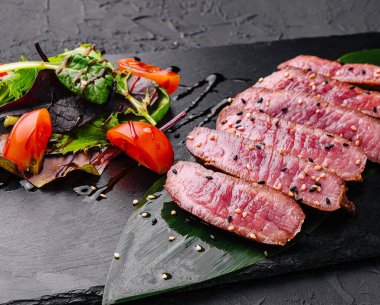 Dilimlenmiş az pişmiş biftek parçaları.